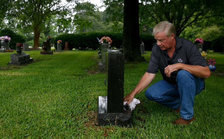 Joe Harrington wipes down the grave of his late wife, Melissa, at Forest Lawn Cemetery in Norfolk, Va. He learned his wife’s killer was interred at Arlington National Cemetery only last year, when he was approached by the co-author of a forthcoming book about death-row inmates. 
