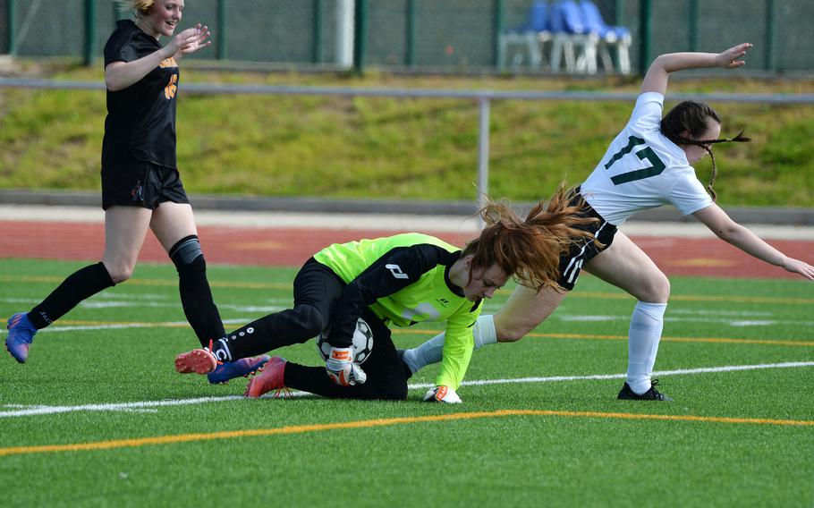 Spangdahlem keeper Isabel Bodily scoops up and protects the ball from AFNORTH’s Isabella Guest in a girls Division III game on opening day of the DODEA-Europe soccer championships in Ramstein, Germany. AFNORTH won the game 3-0.