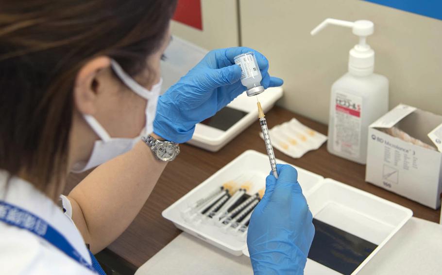 A medical worker with the Japan Ground Self-Defense Force fills a syringe with the Moderna COVID-19 vacine during a shot clinic in Otemachi, Tokyo, Wednesday, June 9, 2021. 