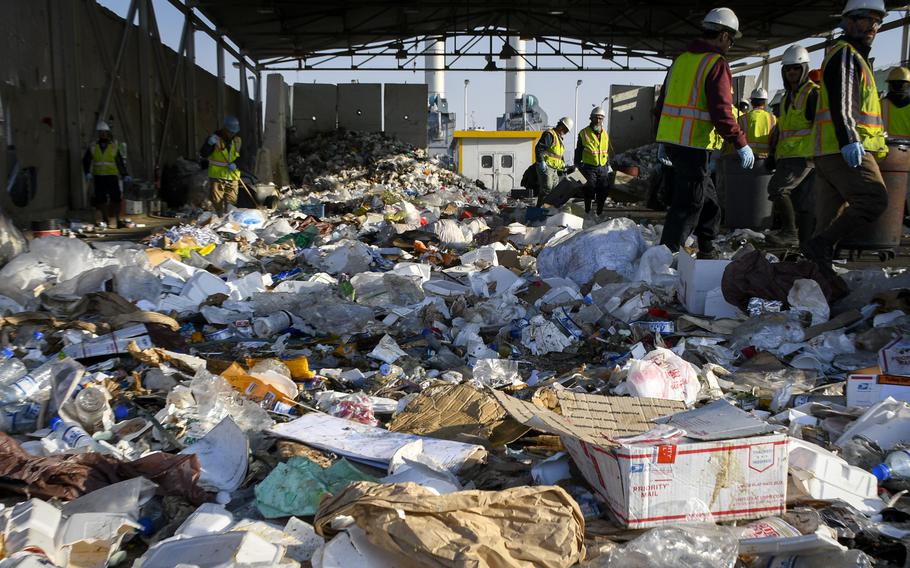 Local contract workers pick through the 70 tons of garbage made each day by U.S. and NATO soldiers at Bagram Airfield, Dec. 14, 2018. The U.S. military is in the process of closing out hundreds of contracts related to the war in Afghanistan, a watchdog agency report released May 4, 2022 said.