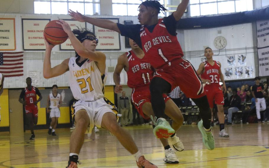 Kadena's Angel Torrado keeps the ball away from Kinnick defendeer Xavier Wright during the Panthers 58-47 win over the Red Devils on Tuesday.