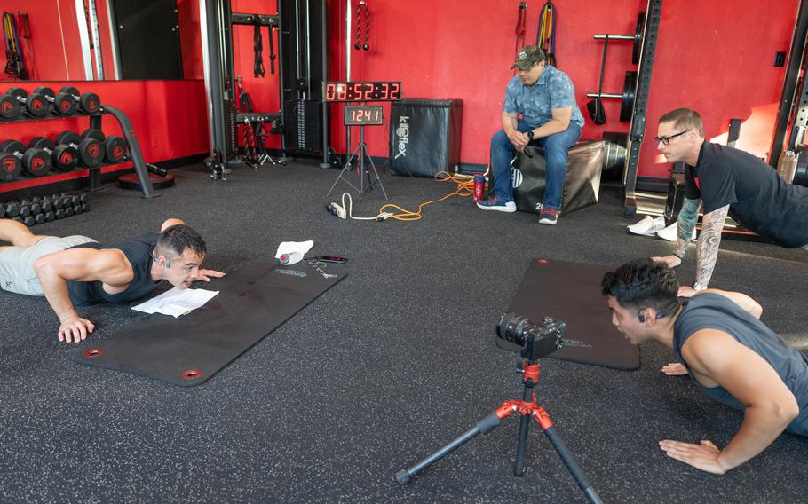 Pedro Velasquez keeps the official count while friends and spectators perform pushups alongside Maj. Tommy Vu 
