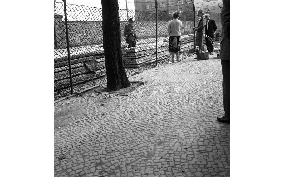 West Berlin citizens look on as the Wall continues to take shape.