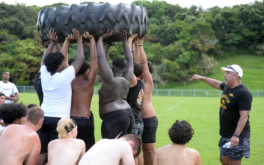 Kadena players carry a heavy tire.