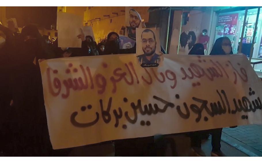 In this image made from video provided by the Bahrain Institute for Rights and Democracy, demonstrators march to protest the death of a prisoner in Diah, Bahrain, Wednesday, June 9, 2021. Hundreds on Wednesday held a rare protest in Bahrain over the death of a vaccinated prisoner from the coronavirus held by the island kingdom. The banner in Arabic reads: "The liberated and honorable martyr has prevailed, the martyr prisoner Husain Barakat."