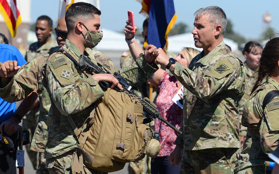 Army Maj. Gen. Charles Costanza, 3rd Infantry Division commander, right, bumps fists with soldiers from his division’s 1st Armored Brigade Combat Team as they board a flight bound for Germany at Hunter Army Airfield, Ga., on Wednesday, March 2, 2022. The brigade was ordered to Europe on a short-notice deployment after Russia invaded Ukraine.