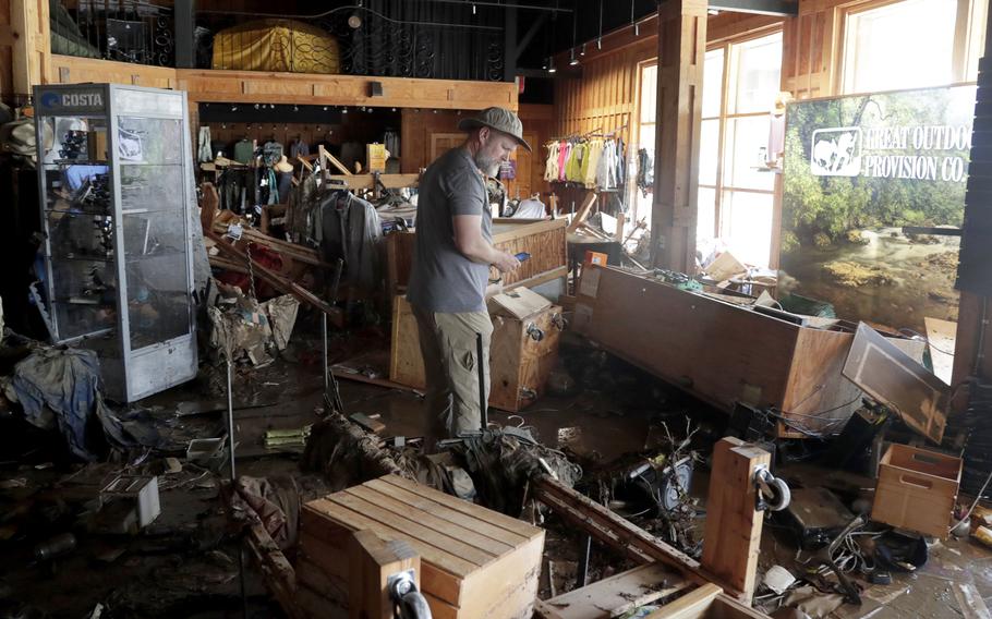 Damage from the flooding in a store includes shelves and boxes flipped over.