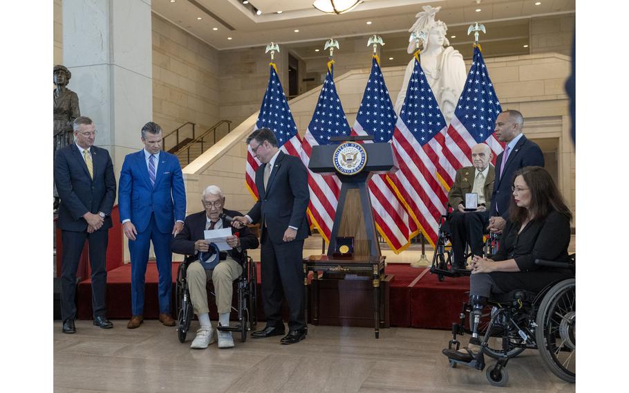 A group of people listen as a veteran speaks.
