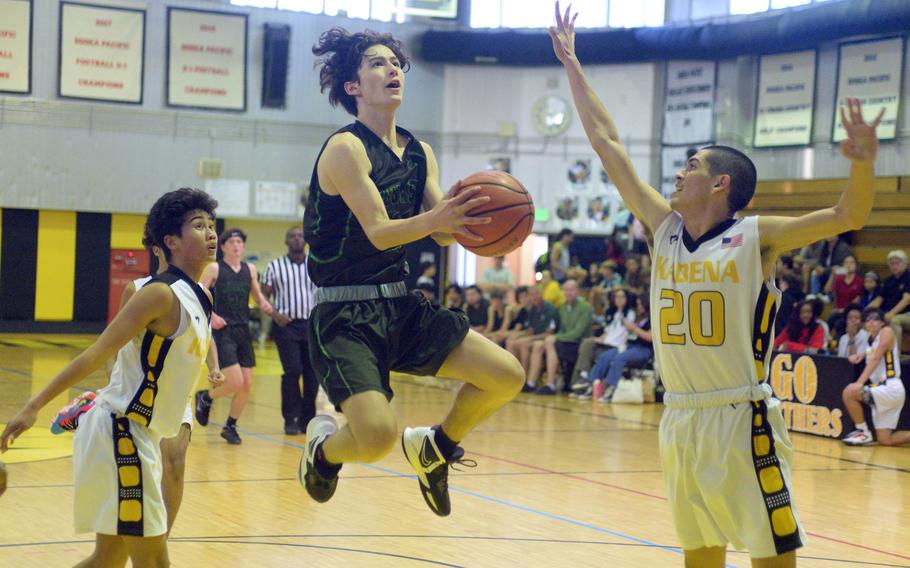 Kubasaki's Troy Harris skies for a shot against Kadena's Jaden Vergara and Noah Ray during Friday's DODEA-Okinawa boys basketball game. The Panthers won 61-52.