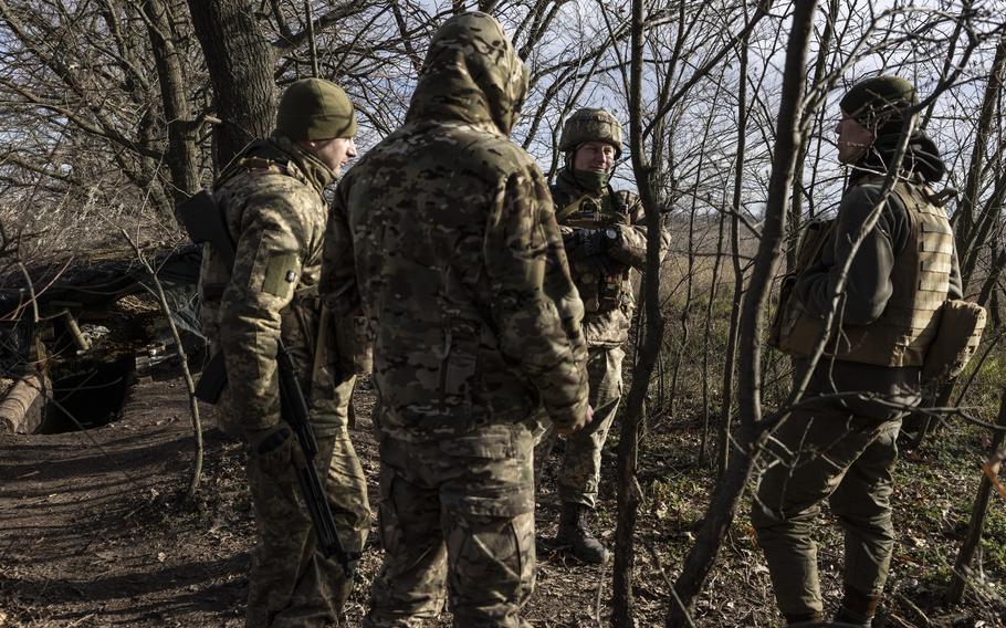 Victor Dadak, center, a deputy battalion commander, speaks with soldiers in the woods at a military position in the Zaporizhzhia region on Nov. 30. 