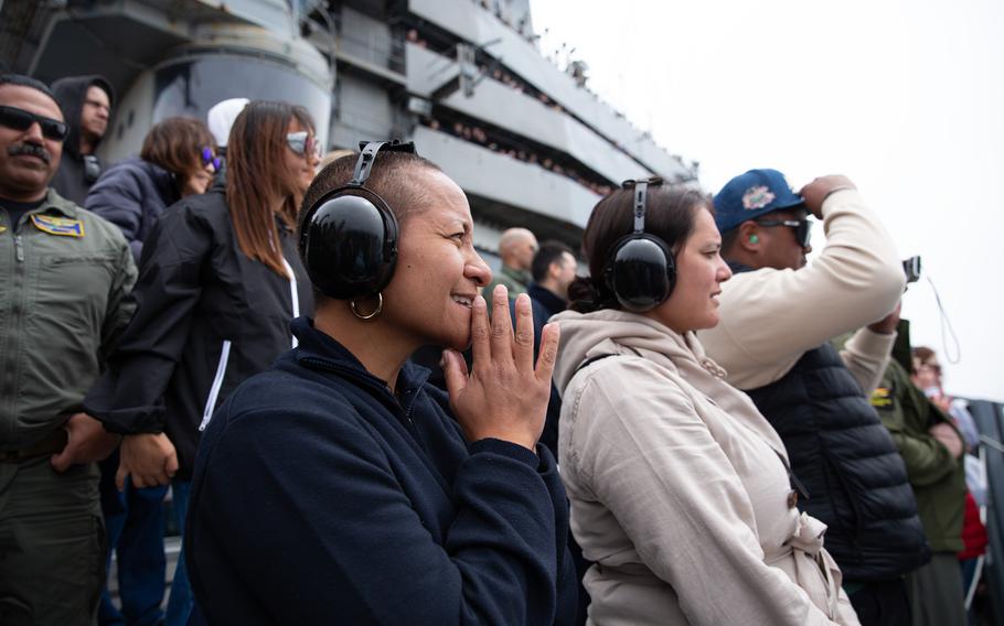 Guests observe an airpower demonstration on the flight deck of the USS Abraham Lincoln