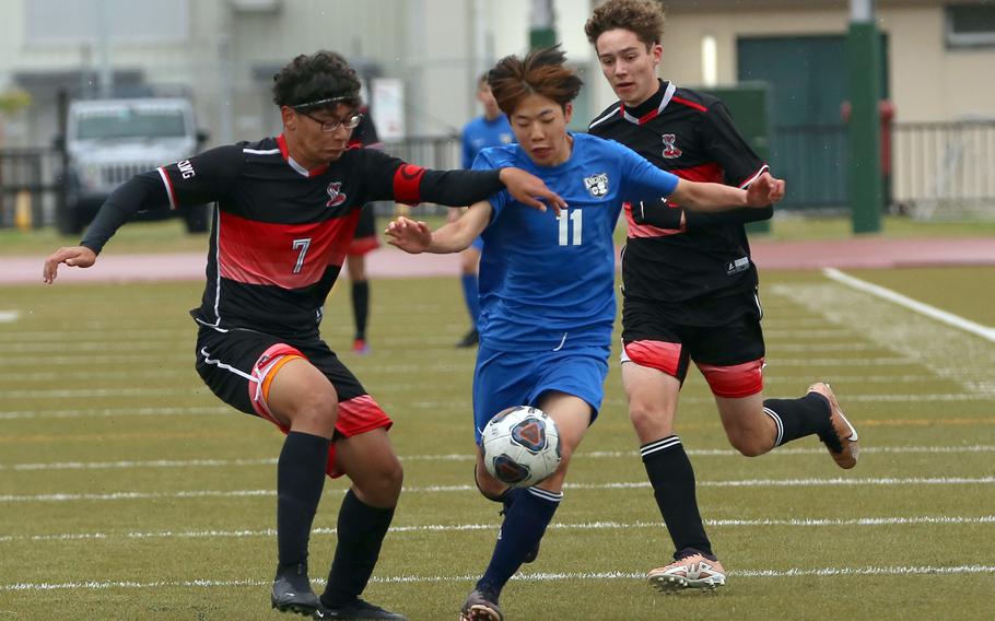Christian Academy Japan's Ryosei Maekawa dribbles between E.J. King's Amin Alipourkashki and Kai Sperl during Tuesday's Division II boys soccer match. The teams played to a 1-1 draw.