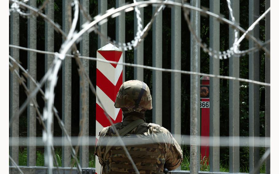 A soldier stands guard near the fence on the Belarusian-Polish border in the forest near Bialowieza, Poland, June 4, 2024.