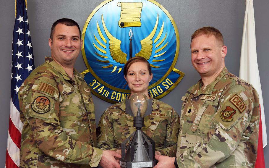Tech. Sgt. Raymond Zgoda, left, a civil engineer with the 374th Airlift Wing; Master Sgt. Sarah Hubert, center, the wing's superintendent of religious affairs; and Lt. Col. Mark Wagner, commander of the 374th Contracting Squadron, pose with their Spark Tank award at Yokota Air Base, Japan, March 15, 2023.