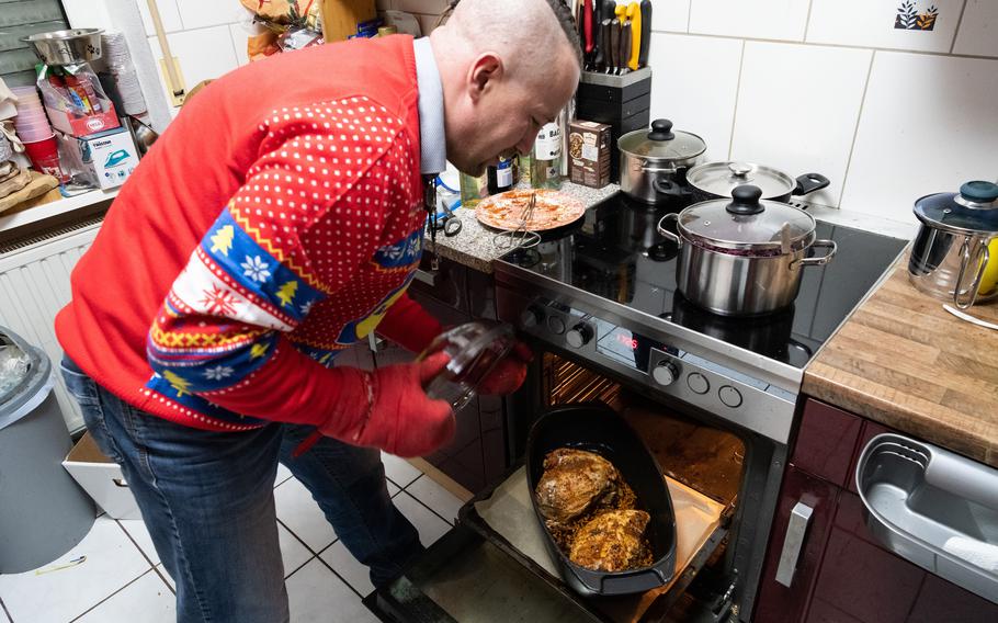 Ulf Buerger checks on dinner at his home in Zweibruecken, Germany, Dec. 24, 2023.