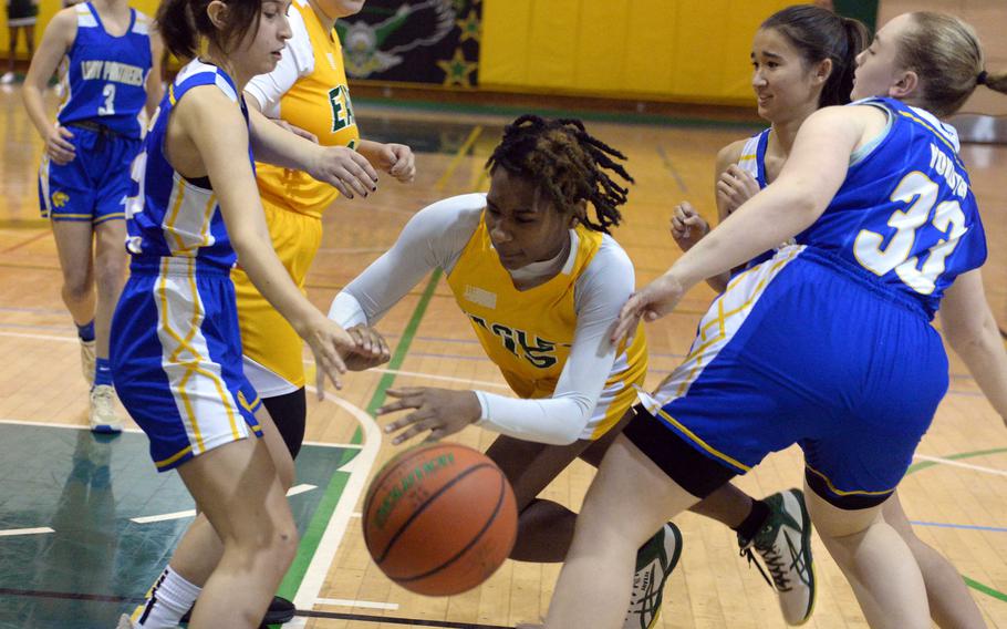 Robert D. Edgren's Jaylie Johnson loses her footing between Yokota defenders during Friday's DODEA-Japan basketball game. The Eagles won 37-25.