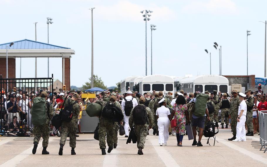 Sailors walk off of Naval Station Norfolk's Pier 14 into a crowd of families after the USS Dwight D. Eisenhower returned from a five-month deployment on July 18, 2021. on Friday, Aug. 27, 2021, Navy  installations across Hampton Roads, Va., moved to condition Charlie because of an increase in COVID cases.