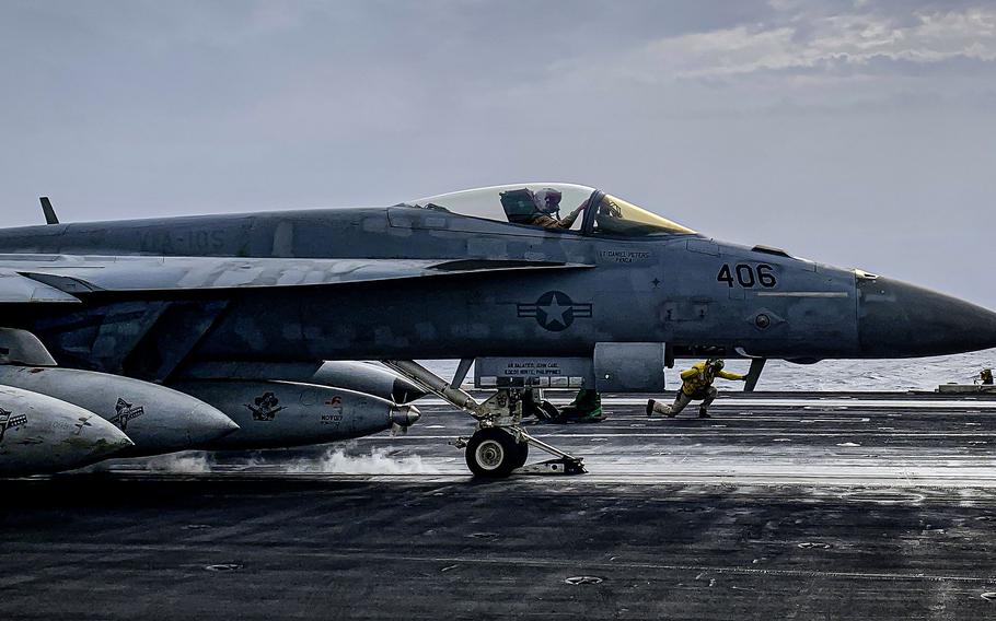 A fighter jet on a carrier flight deck.