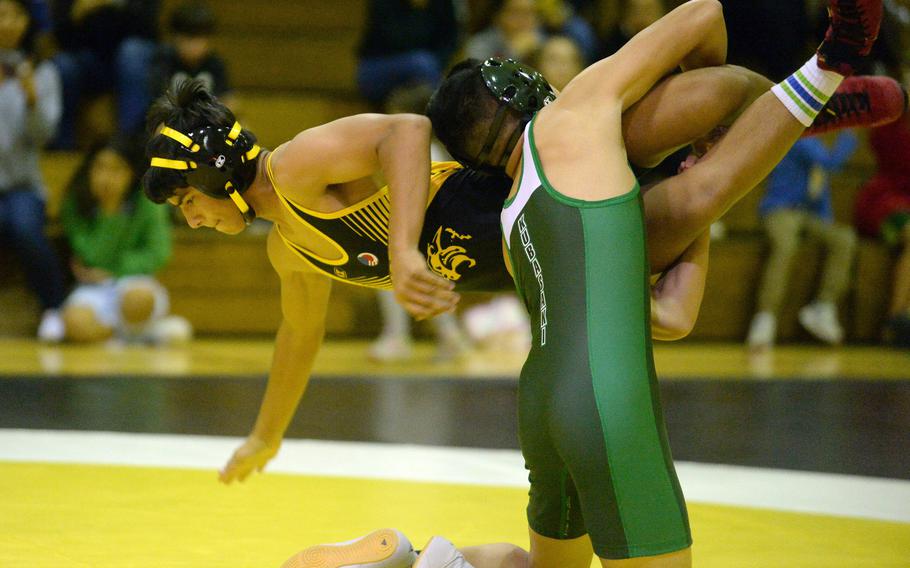 Kubasaki’s Gavin Ocampo lifts Kadena’s Ryan Luckey at 122 pounds during Wednesday’s Okinawa wrestling dual meet. Ocampo won by technical fall 10-0 in 1 minute, 4 seconds, and the Dragons took the meet 40-23.