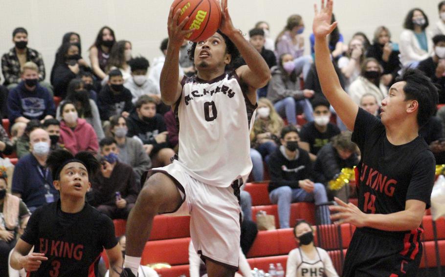 Matthew C. Perry's Denzel Gray drives for a shot between E.J. King's Arjae Laurente and Shan Casimiro during Friday's DODEA-Japan boys basketball game. The Samurai won 50-31.