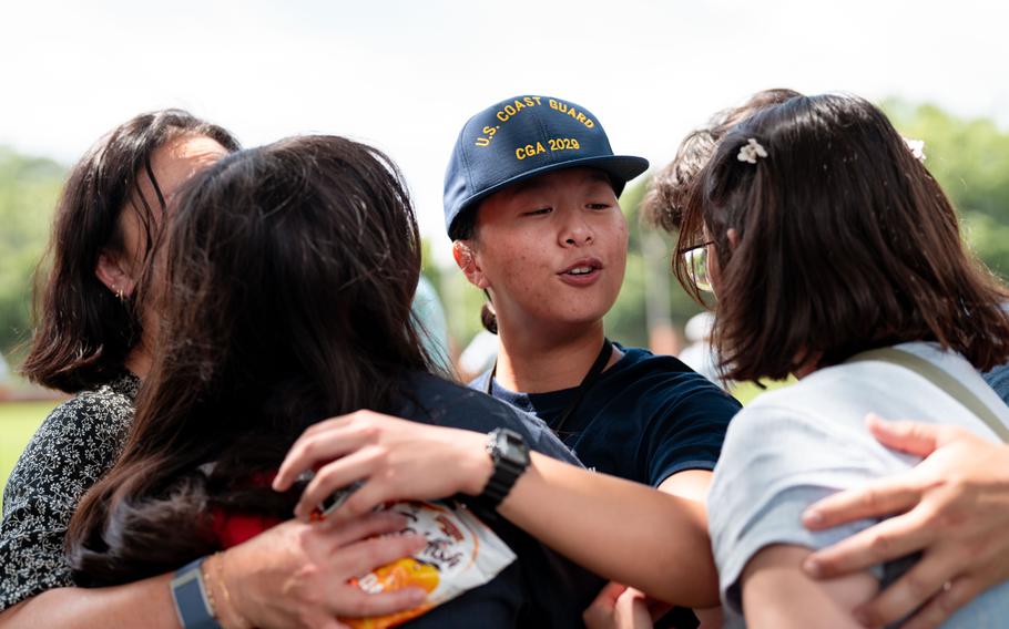 A Coast Guard Academy cadet embraces a loved one