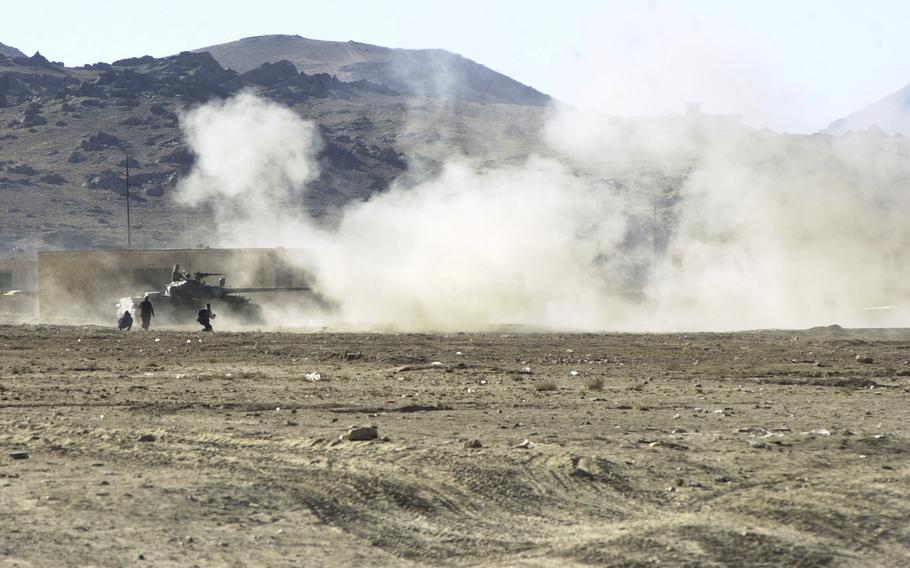 A Northern Alliance Soviet-era tank blasts away at Taliban positions south of Kabul, Nov. 23, 2001. A fierce battle has been unfolding there in recent days as the opposition forces try to consolidate power and seize the final remaining pockets of the country still under Taliban control.