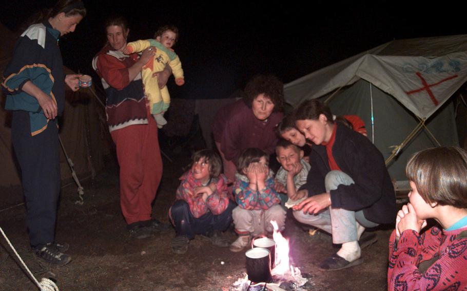 Residents of the Brazda refugee camp gather around a fire as nightime settles in. The evening hours seem to  magically draw refugees out of their tents and they begin to socialize.