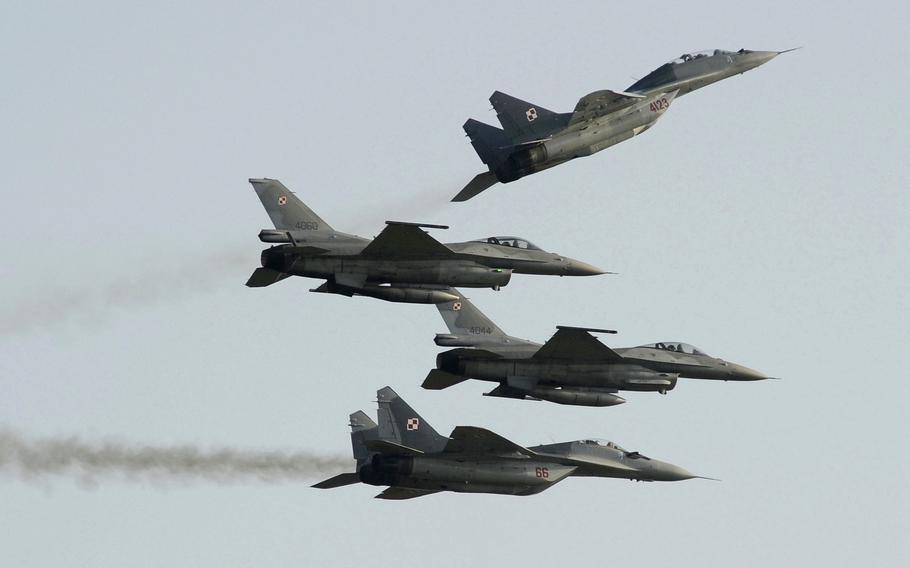 Two Polish Air Force Russian made Mig 29s fly above and below two Polish Air Force U.S. made F-16 fighter jets during the Air Show in Radom, Poland, on Aug. 27, 2011. 