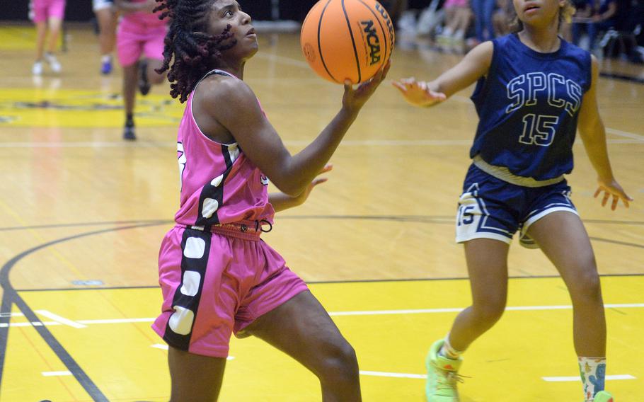 Kadena's NyKale Penn drives against St. Paul Christian's Ryanna Ngirchomlei during Satuday's girls championship game in the 5th American School In Japan Kanto Classic basketball tournament. The Warriors outalsted the Panthers 38-33.
