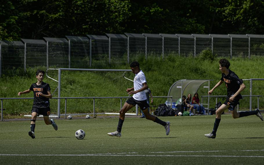 Eugene Lewis of Baumholder sprints past Spangdahlem’s Mason Tieyah, right, and James Idems during the 2024 DODEA European Soccer Division III Championships in Landstuhl, Germany, on May 20, 2024.