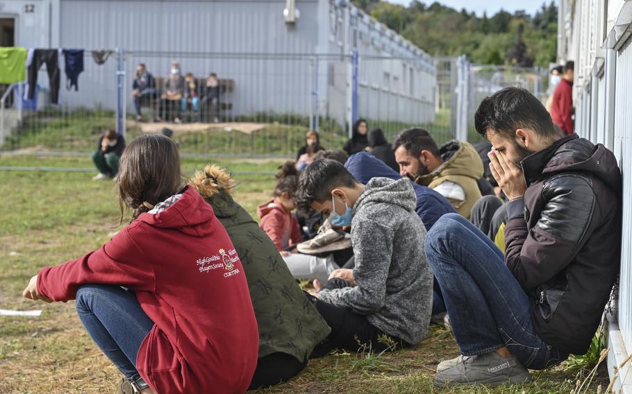 Migrants sit in front of containers at the Central Initial Reception Facility for Asylum Seekers, ZABH, in the federal German state of Brandenburg in Eisenhuettenstadt, Germany, Wednesday, Oct. 6, 2021. German federal police said more than 4,300 people crossed the border from Poland ‘illegally’ this year. Most people are being put up at asylum centers in the eastern state of Brandenburg.