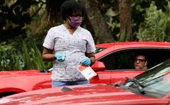 A healthcare worker provides COVID-19 tests at a drive-thru site located in Snyder Park on Jan. 5, 2022, in Fort Lauderdale, Florida. 