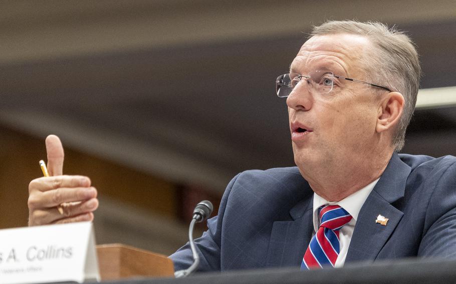Doug Collins is seated and gestures with his right hand as he speaks.