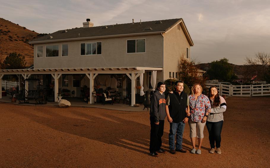 Mary Lyn Martinez and her her husband Duane and daughter Cassidy (right) and son Troy (far left) stand in their backyard for a portrait as they prepare to host a scaled down Thanksgiving dinner for only immediate family members on Thursday, Nov. 18, 2021 in Acton, Calif. 