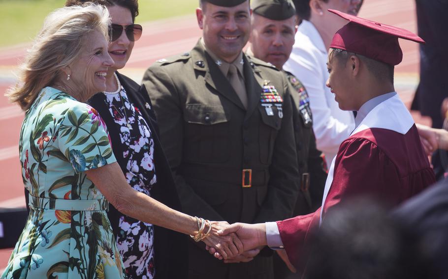 First lady Jill Biden congratulates a Matthew C. Perry High School senior during a pre-graduation ceremony at Marine Corps Air Station Iwakuni, Japan, Sunday, May 21, 2023.