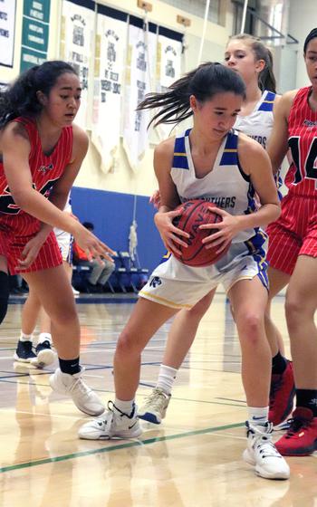 Yokota's Erica Hass pulls down a rebound and plays keep away from Nile C. Kinnick's Naima Mincey, left, and Kotone Turner.