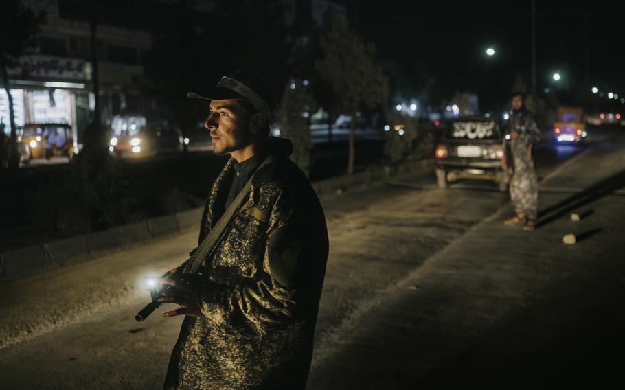 A young Taliban member inspects vehicles at a checkpoint in Kabul, Afghanistan, on Oct. 5. 