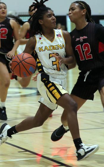 Kadena's NyKale Penn drives against Kinnick's KaMiyah Dabner in the girls D-I final.