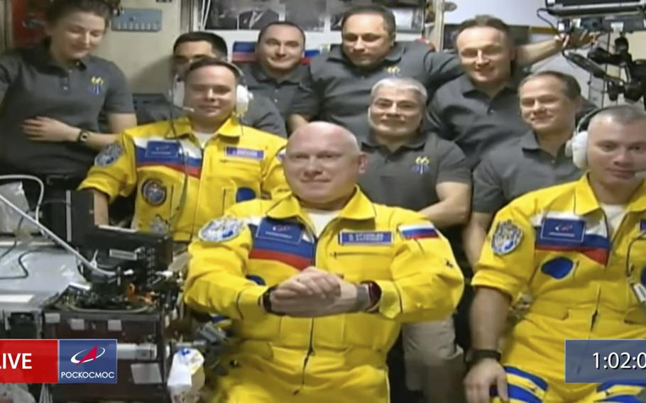 A video screen grab show Russian cosmonauts Sergey Korsakov, Oleg Artemyev and Denis Matveyev during a welcome ceremony after arriving at the International Space Station, on Friday, March 18, 2022, the first new faces in space since the start of Russia’s war in Ukraine. The crew emerged from the Soyuz capsule wearing yellow flight suits with blue stripes, the colors of the Ukrainian flag.