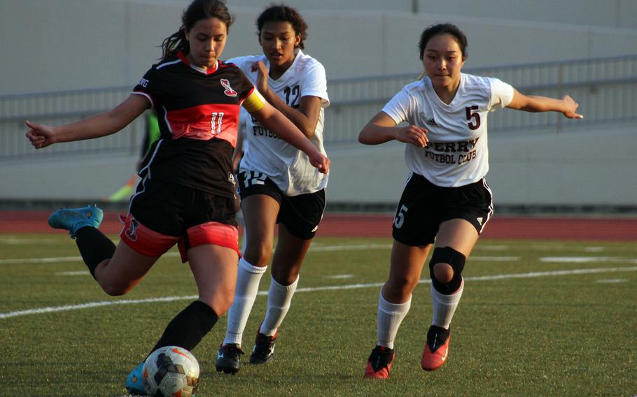E.J. King's Maliwan Schinker boots the ball against Matthew C. Perry's Towa Albsmeyer and Soledad Arce during Friday's DODEA-Japan soccer match. The teams played to a 1-1 draw.