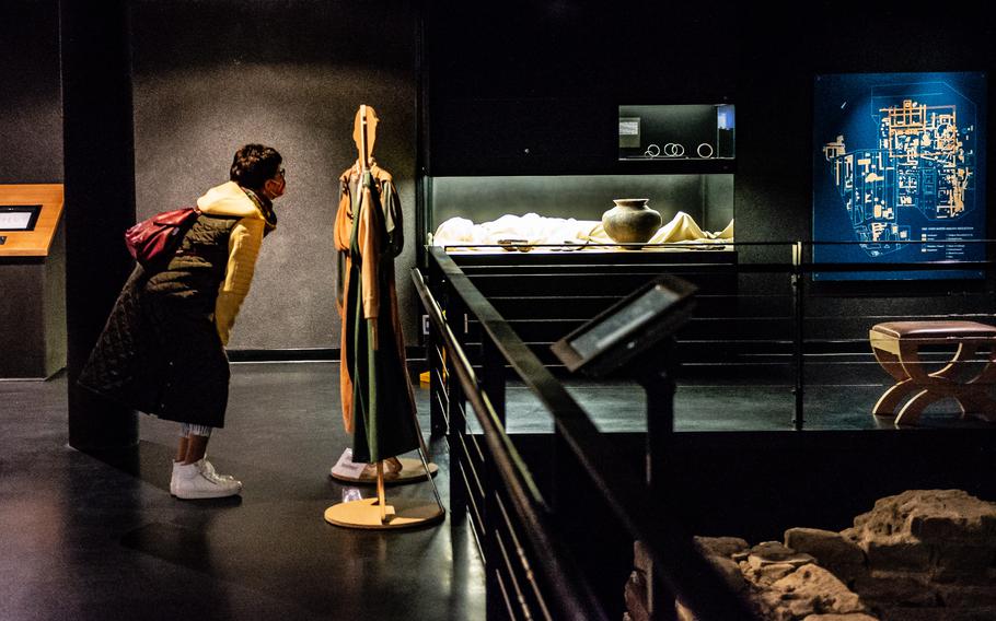 A visitor examines reproductions of Roman clothing at the Isis and Mater Magna shrine in Mainz, Germany, on Nov. 10, 2022. The temple grounds once constituted a large complex that allowed Roman soldiers, settlers and travelers to worship oriental deities such as Isis, who was believed to help the dead enter the afterlife. 