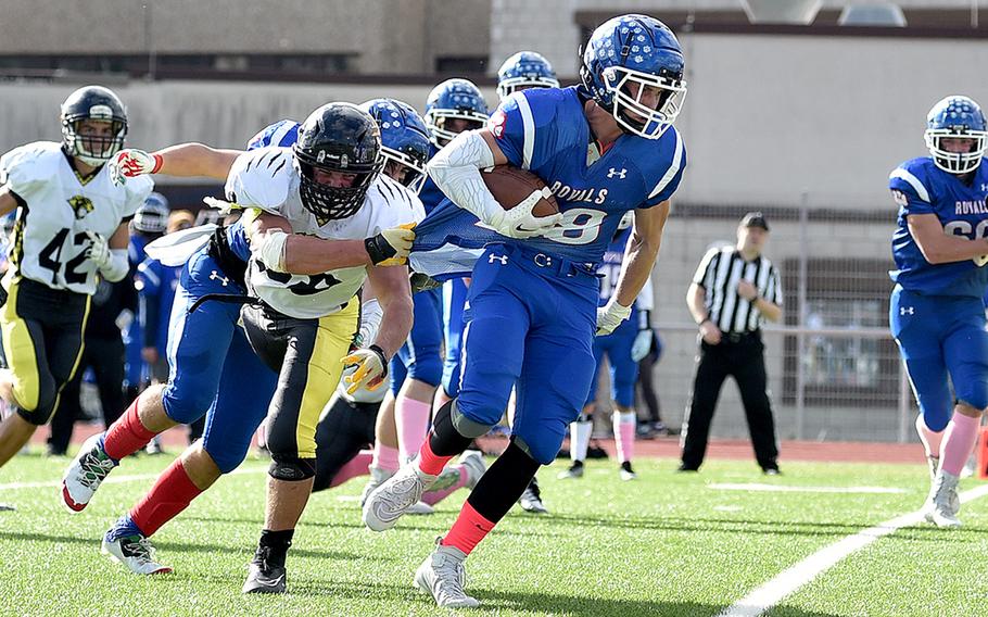 Stuttgart linebacker Jack Gruver latches onto the jersey of Royal running back Ethan Wilson during a Division I football semifinal on Oct. 21, 2023, at Ramstein High School on Ramstein Air Base, Germany.