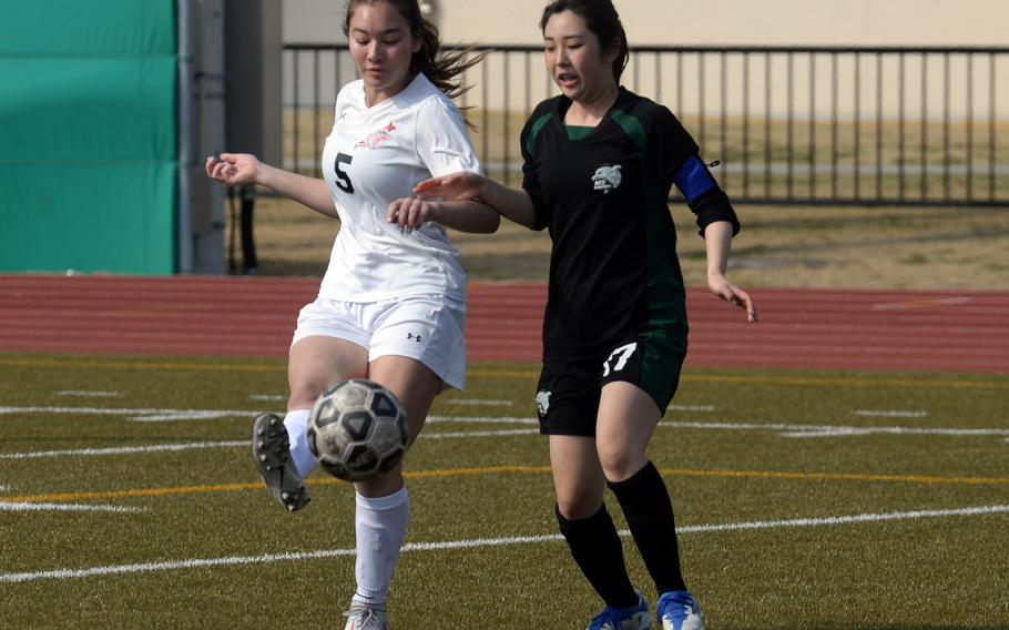 E.J. King's Aileen FitzGerald fires the ball for a goal past Nagoya International defender Otoha Yasui during Friday's Western Japan Athletic Association girls soccer tournament. The Cobras won 8-0.