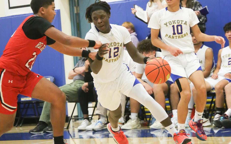 Yokota's Jai Bailey drives against Nile C. Kinnick's Misiah Morizane during Tuesday's DODEA-Japan/Kanto Plain boys basketball game. The Red Devils won 73-61 despite Bailey scoring 30 points for the Panthers.