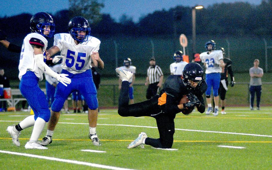 Sentinel defender Jeremy White goes to ground after intercepting a pass durign a Sept. 29, 2023, game at Spangdahlem High School in Spangdahlem, Germany. Watching, from left, are Brussels players Rio Rogers and Antonio Pranjic.