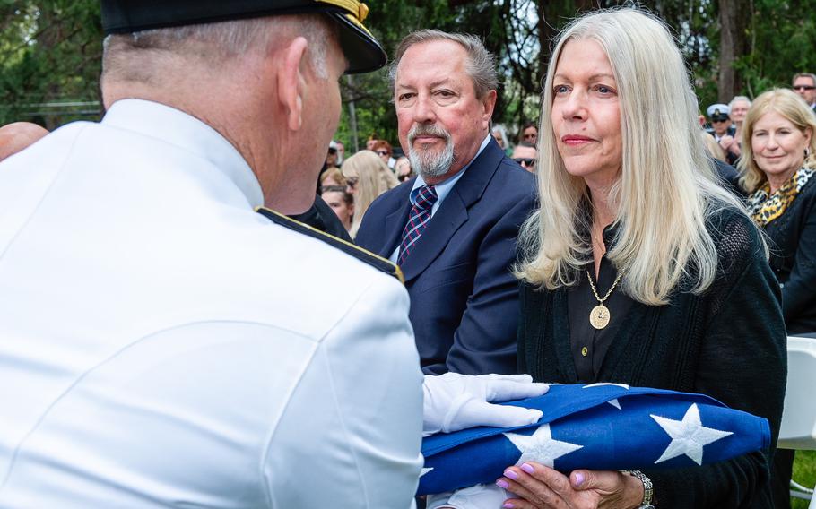 Louann Daley, retired Lt. Cmdr. Lou Conter’s daughter, receives a flag from Rear Adm. Richard Brophy, chief of Naval Air Training, at Conter’s memorial service.