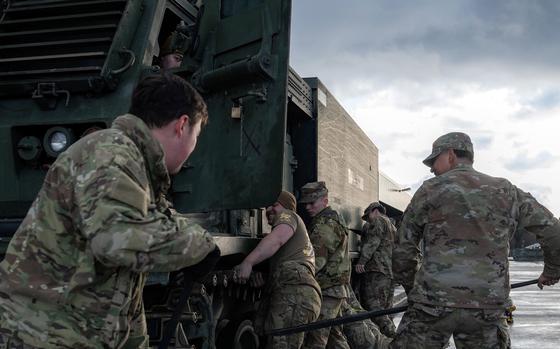 Soldiers assigned to 1st Battalion, 6th Field Artillery Regiment lift a new track into place on an M270 Multiple Launch Rocket System in Grafenwoehr, Germany, on Feb. 1, 2024.
