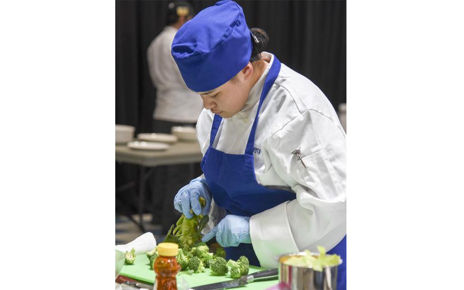 Yokota High School student Maria Post chops broccoli during the Far East Culinary Arts Competition at Yokota Air Base, Japan, Feb. 7, 2023.