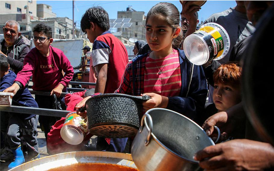 Palestinians gather to receive food from a charity kitchen in Rafah, in the southern Gaza Strip on May 8, 2024.