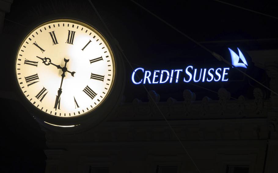 The illuminated logo of Swiss bank Credit Suisse is seen behind a clock at the bank’s headquarters at Paradeplatz in Zurich, Switzerland, on Saturday, March 18, 2023.